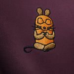 Detailaufnahme der Maus Relax-Stickerei auf dem bordeauxroten Half Zip. Die meditierende Maus im Lotussitz.