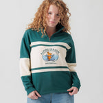 Vorderansicht eines weiblichen Models im grün-cremefarbenen Half Zip mit Maus Alpine-Motiv.