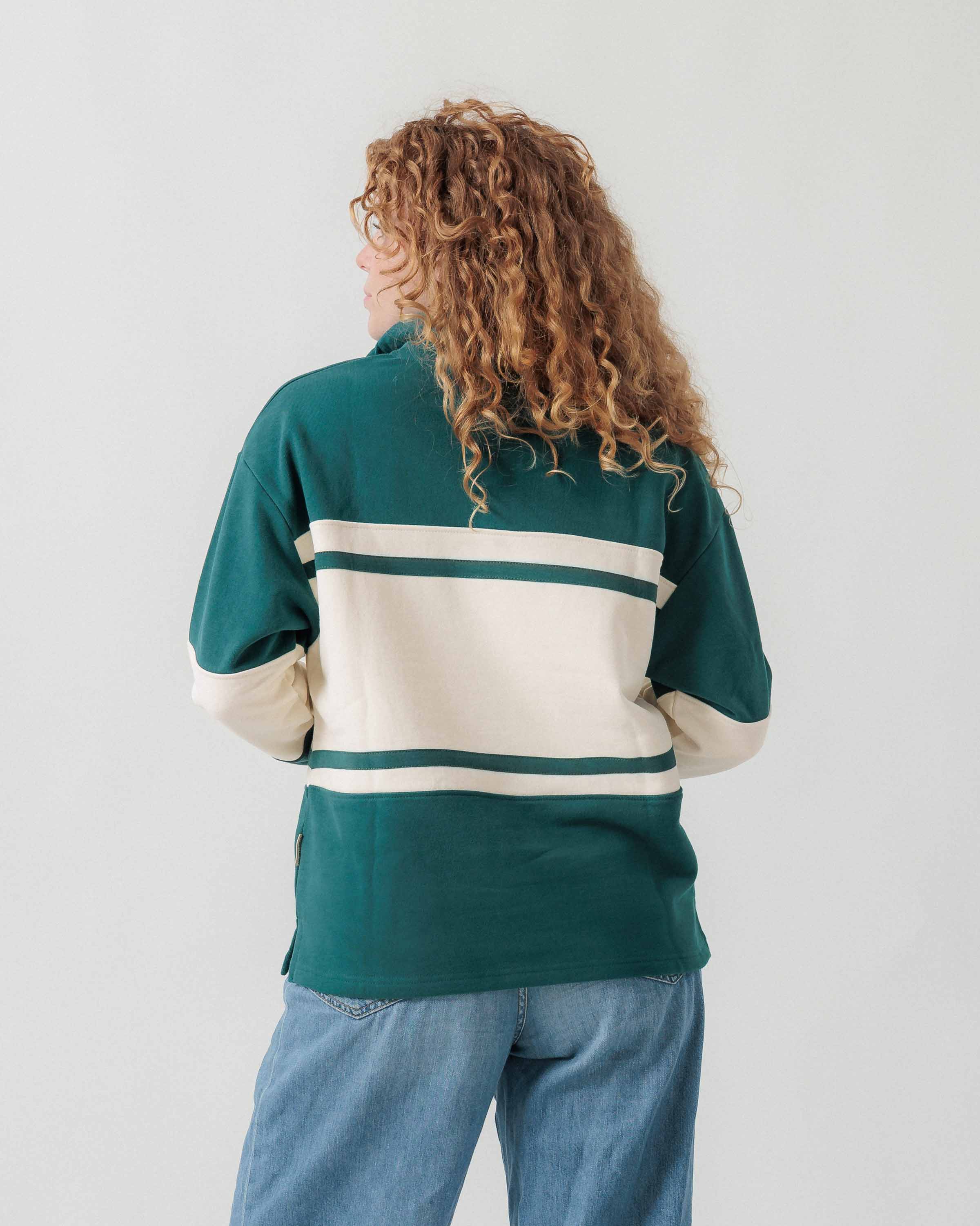 Rückansicht eines weiblichen Models im grün-cremefarbenen Half Zip.