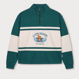 Vorderansicht des grün-cremefarbenen Half Zips mit Maus Alpine-Motiv. Maus auf Skiern vor einer Bergkulisse.