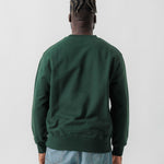 Rückansicht eines männlichen Models im grünen Box Sweater.