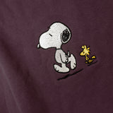 Detailaufnahme der Snoop Läuft-Stickerei auf dem bordeauxroten Hoodie. Der entspannte Snoopy, der gemeinsam mit Woodstock spaziert.