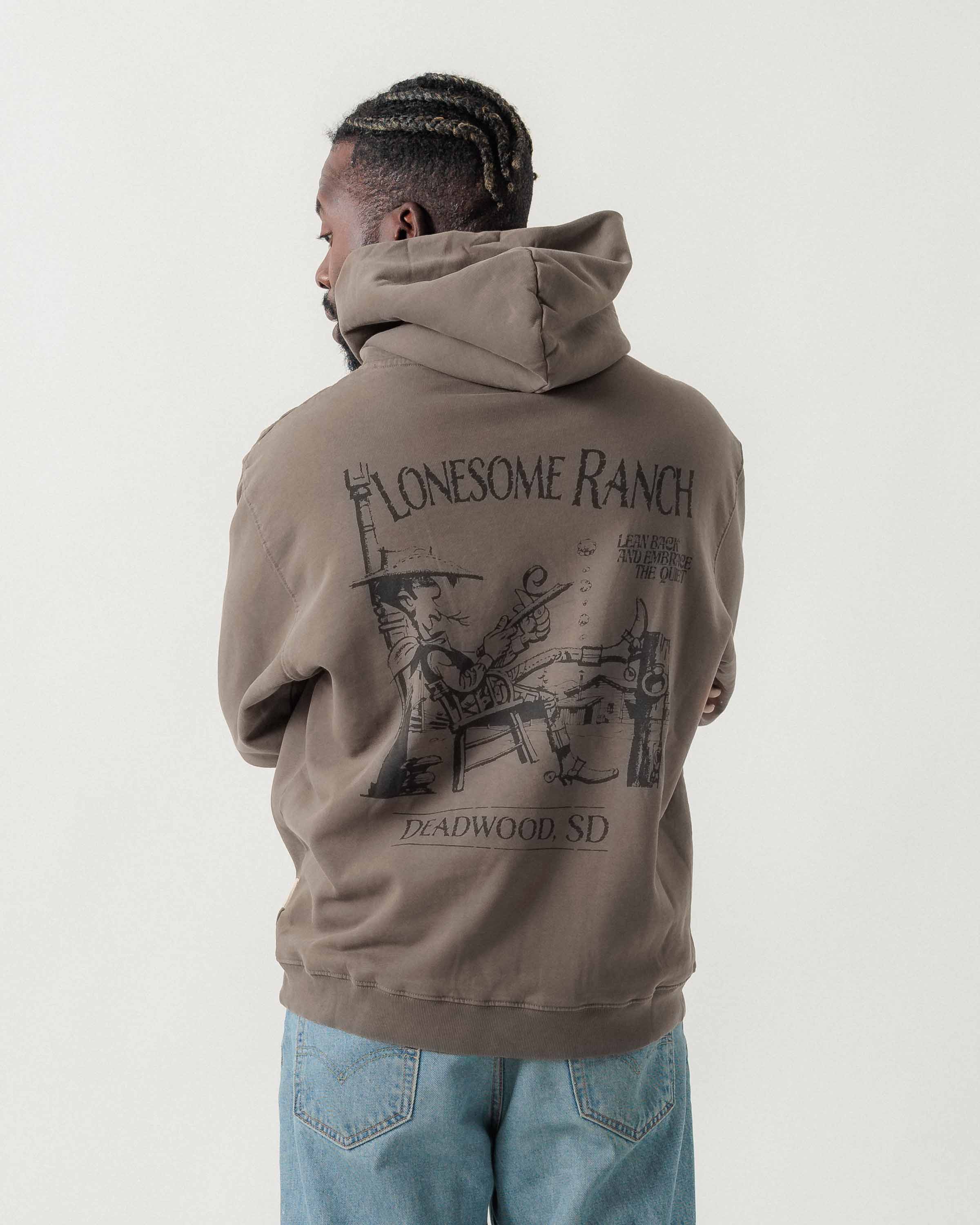 Rückansicht eines männlichen Models im grauen Boxer Hoodie mit Lucky Luke Lonesome Ranch-Print.