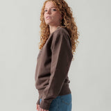 Seitenansicht eines weiblichen Models im braunen Box Sweater.