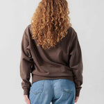 Rückansicht eines weiblichen Models im braunen Box Sweater.