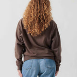 Rückansicht eines weiblichen Models im braunen Box Sweater.