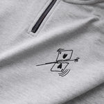 Detailaufnahme der Vorderseite des grauen Half Zips mit einer von einer Kugel durchbohrten Spielkarte auf der Brust.