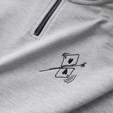 Detailaufnahme der Vorderseite des grauen Half Zips mit einer von einer Kugel durchbohrten Spielkarte auf der Brust.