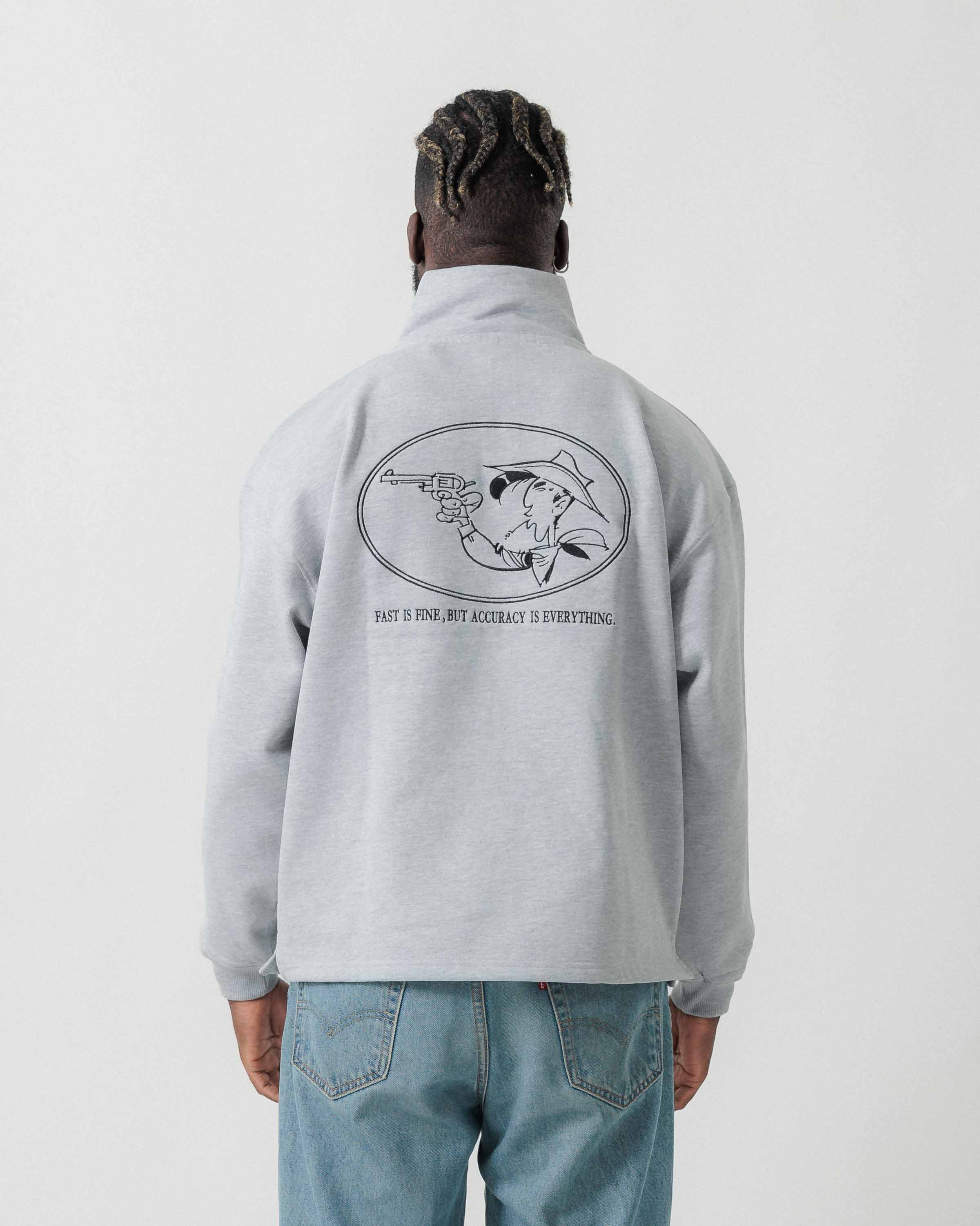 Rückansicht eines männlichen Models im grauen Half Zip mit Lucky Luke Accuracy-Stickerei.