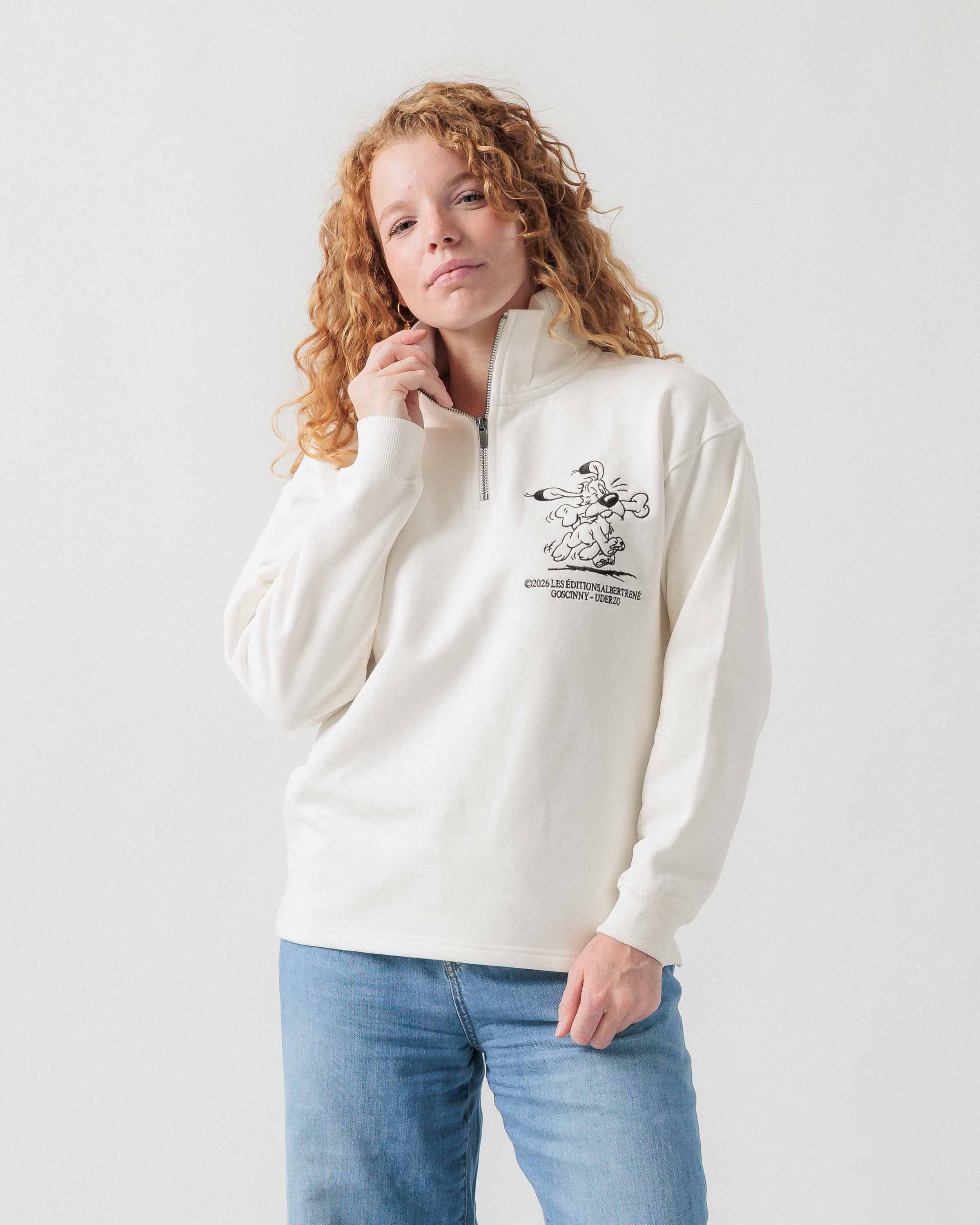Vorderansicht eines weiblichen Models im weißen Half Zip mit Idéfix Happy-Stickerei.