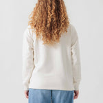Rückansicht eines weiblichen Models im weißen Half Zip.