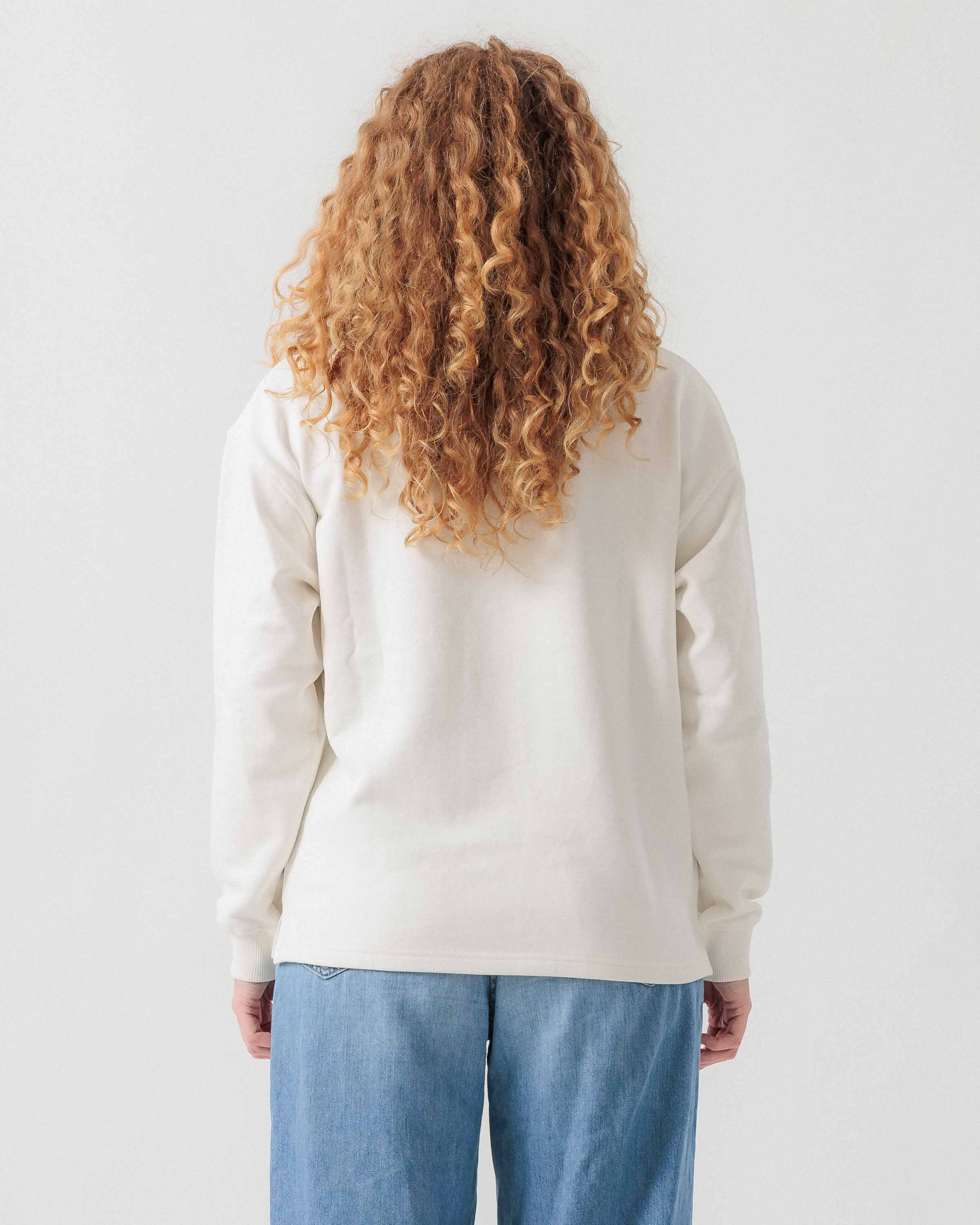 Rückansicht eines weiblichen Models im weißen Half Zip.