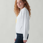 Seitenansicht eines weiblichen Models im weißen Sweater.