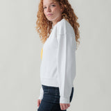 Seitenansicht eines weiblichen Models im weißen Sweater.