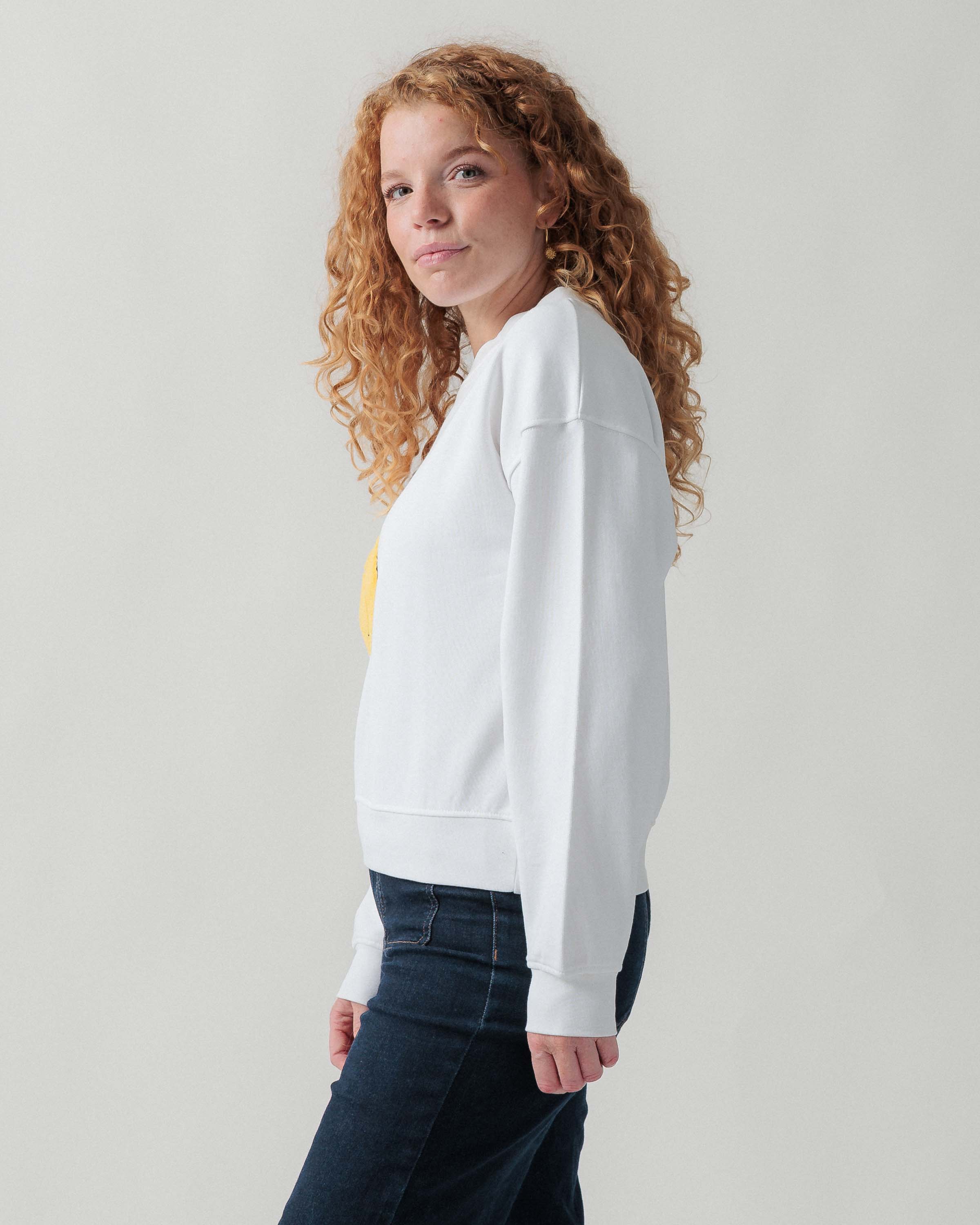 Seitenansicht eines weiblichen Models im weißen Sweater.