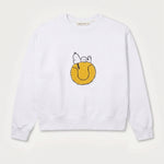 Vorderansicht des weißen Sweaters mit Snoopy Tennisball-Motiv. Tennisball, auf dem Snoopy tiefenentspannt relaxt.