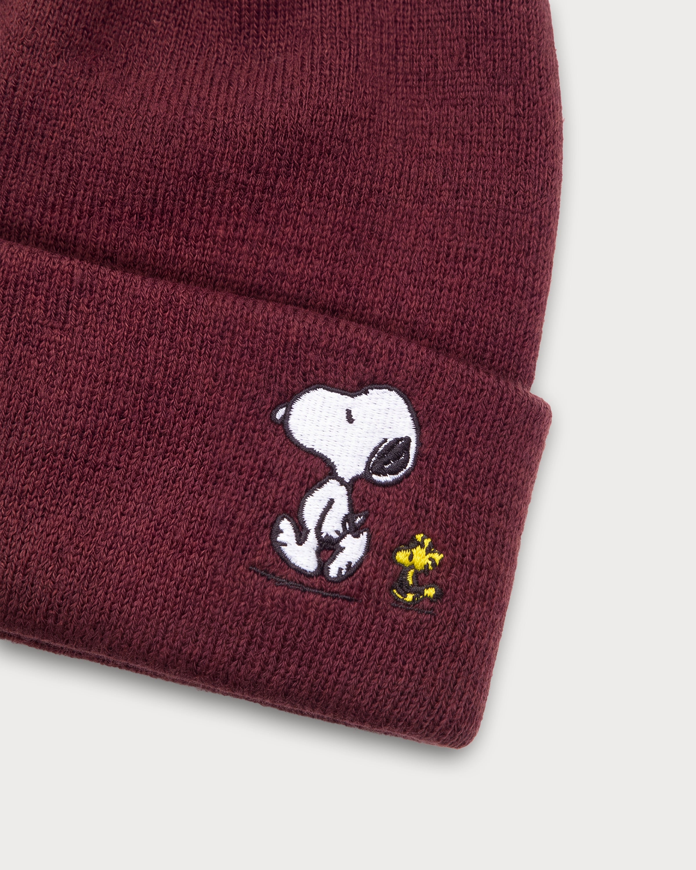 Detailaufnahme der Snoopy Läuft-Stickerei auf der braunen Beanie.